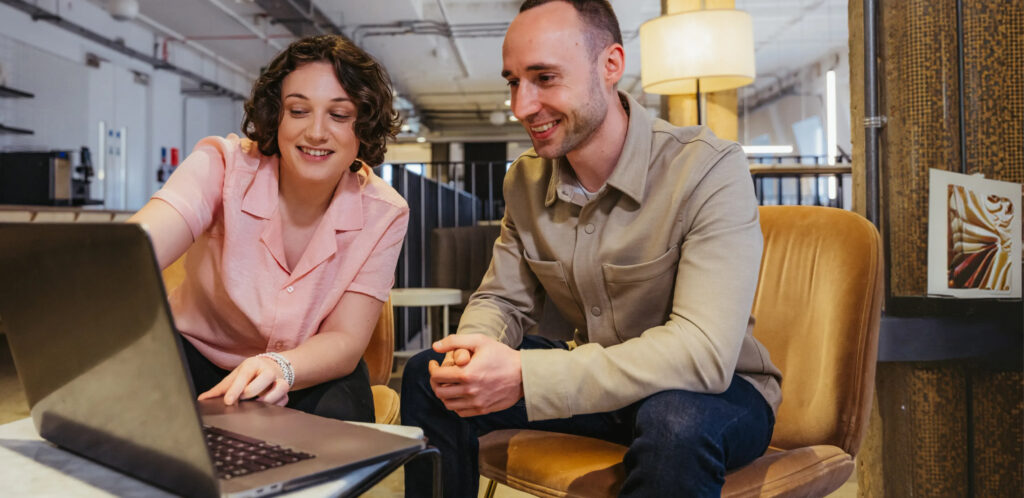 Two people looking at a laptop at work