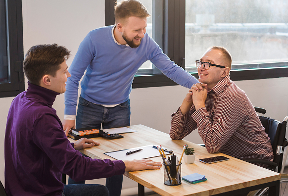 A man giving a colleague some encouragement at work